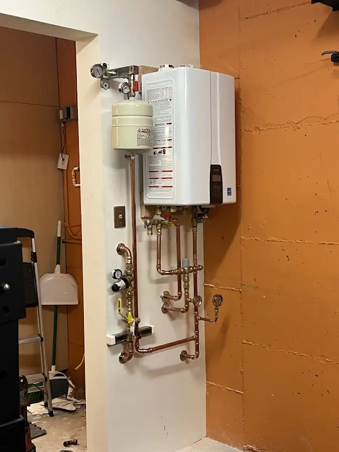 Plumbing technician inspecting water heater connections in Haverhill